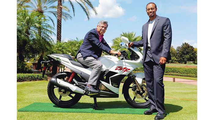 Ο ιδιοκτήτης της Hero Motocorp, Pawan Munjal, καβάλα στη μοτοσικλέτα, και ο πασίγνωστος αθλητής του γκολφ, Tiger Woods, όρθιος δίπλα.