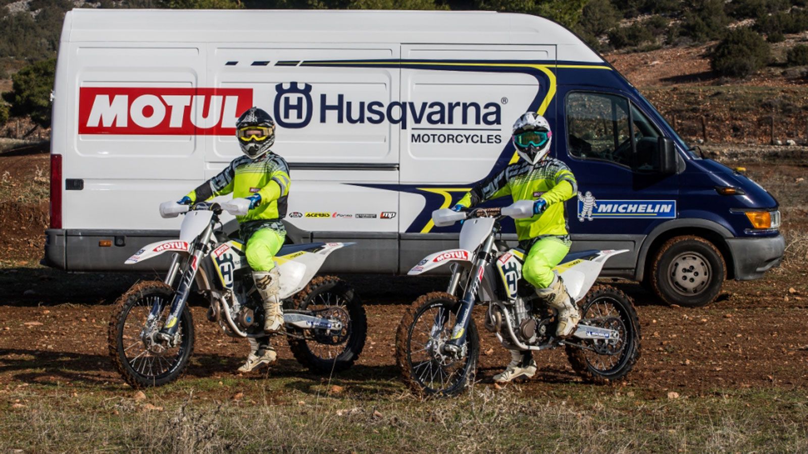 Οι δύο αναβάτες της Husqvarna-Motul MX Team στις μοτοσυκλέτες τους, μπροστά στο φορτηγάκι της ομάδας.