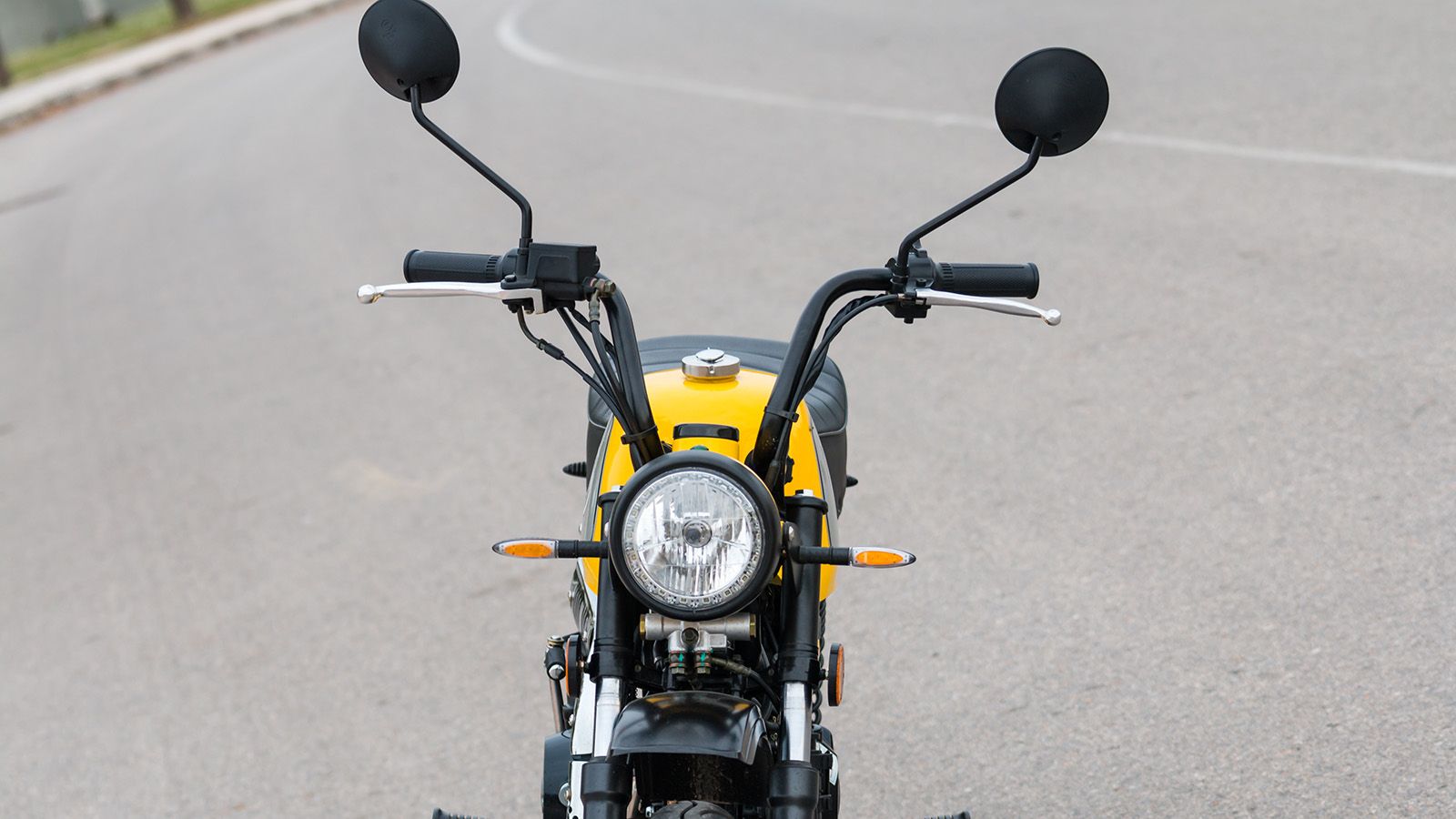 Ape hanger στυλ τιμονιού, στρογγυλός προβολέας και αναχρονιστικοί καθρέπτες, συνθέτουν την ρετρό άποψη του εμπρός μέρους. 