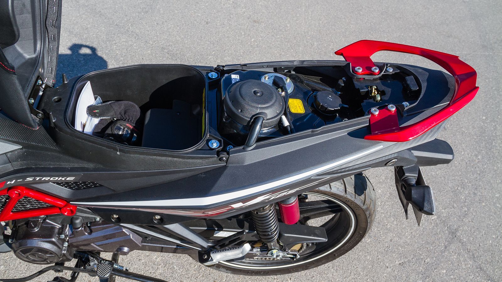 Το ηλεκτρικό άνοιγμα της σέλας αποκαλύπτει έναν αξιοπρεπή χώρο αποθήκευσης κάτω από αυτήν, στοιχείο σπάνιο στην κατηγορία των παπιών.