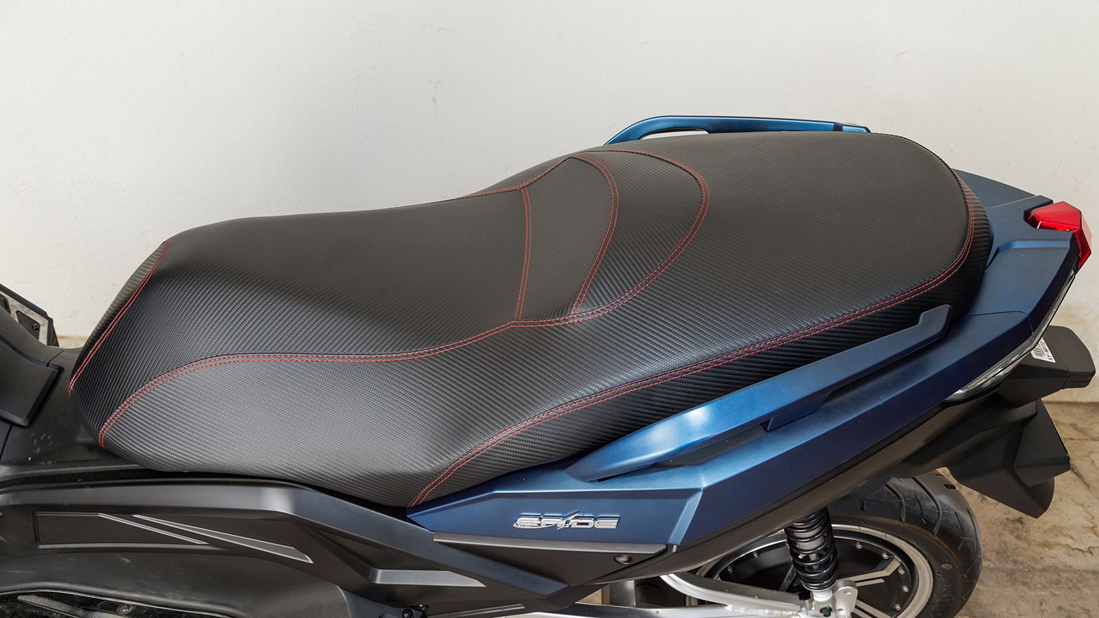 Σέλα: Η μεγάλη σε μέγεθος μονοκόμματη σέλα προσφέρει άνετη χρήση σε οδηγό και συνεπιβάτη, ενώ το κάλυμμα της είναι αντιολισθητικό με όμορφες κόκκινες 