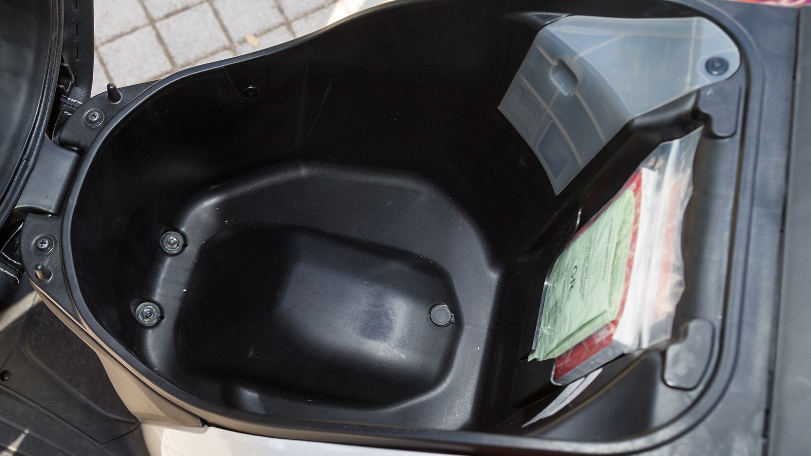 Το «κυκλικό» σχήμα του χώρου κάτω από την σέλα μπορεί να φιλοξενήσει ένα κράνος κλειστού τύπου. Προσέξτε τους δύο «κώνους» μπροστά: Είναι γατζάκια για