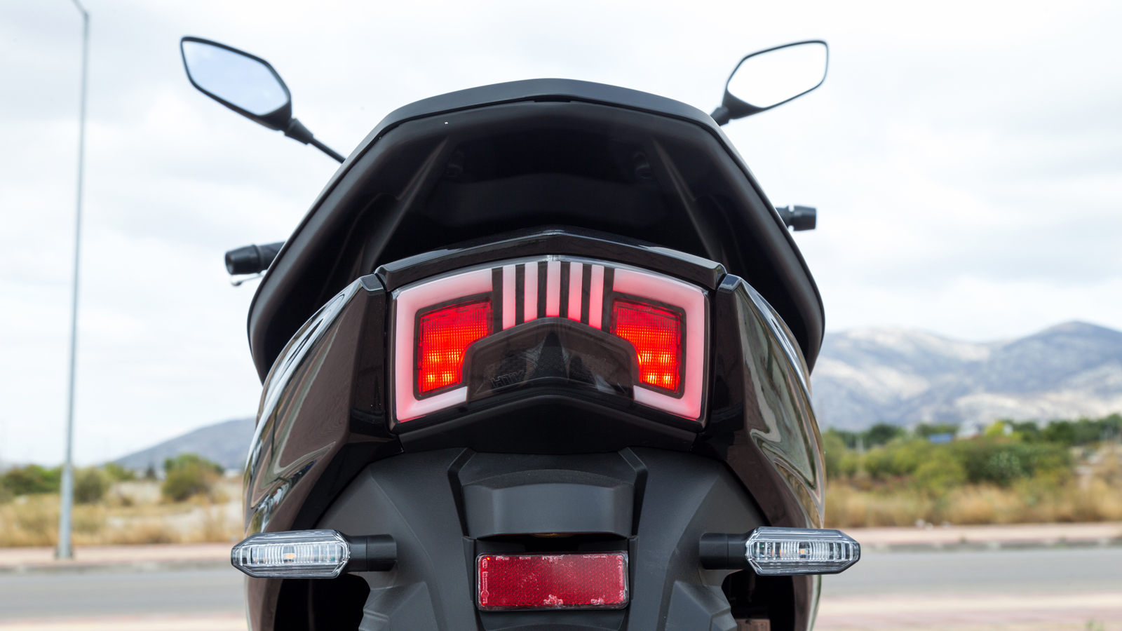 Στην ουρά ο πίσω προβολέας αποκτά ένα πιο φουτουριστικό, τετραγωνισμένο σχέδιο, με την σχάρα να ενσωματώνεται κομψά στην σιλουέτα του scooter.