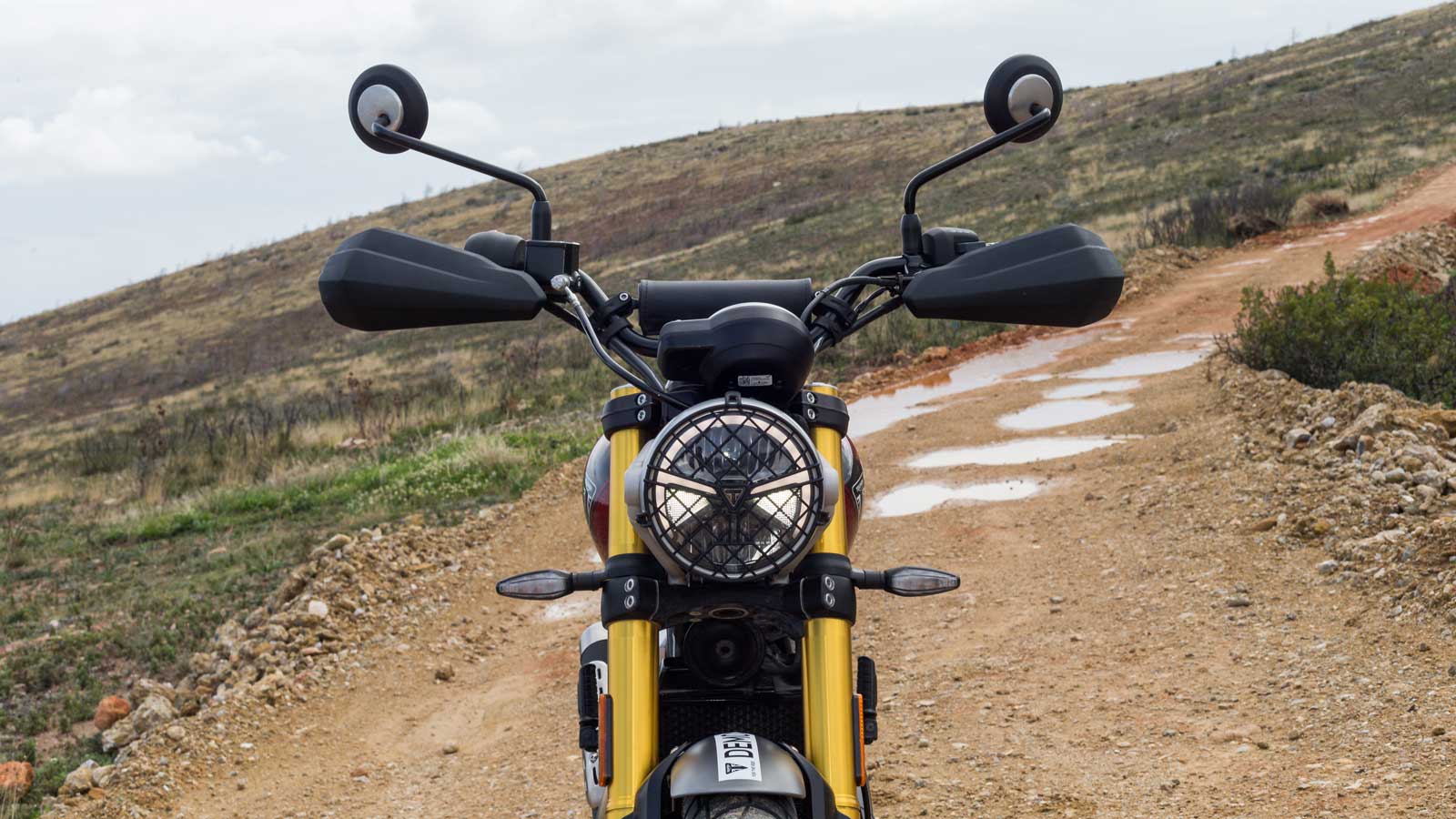 Στρόγγυλος μπροστινός LED προβολέας με το λογότυπο της Triumph στο κέντρο και το δαχτυλίδι της δέσμης φώτων ημέρας DRL.