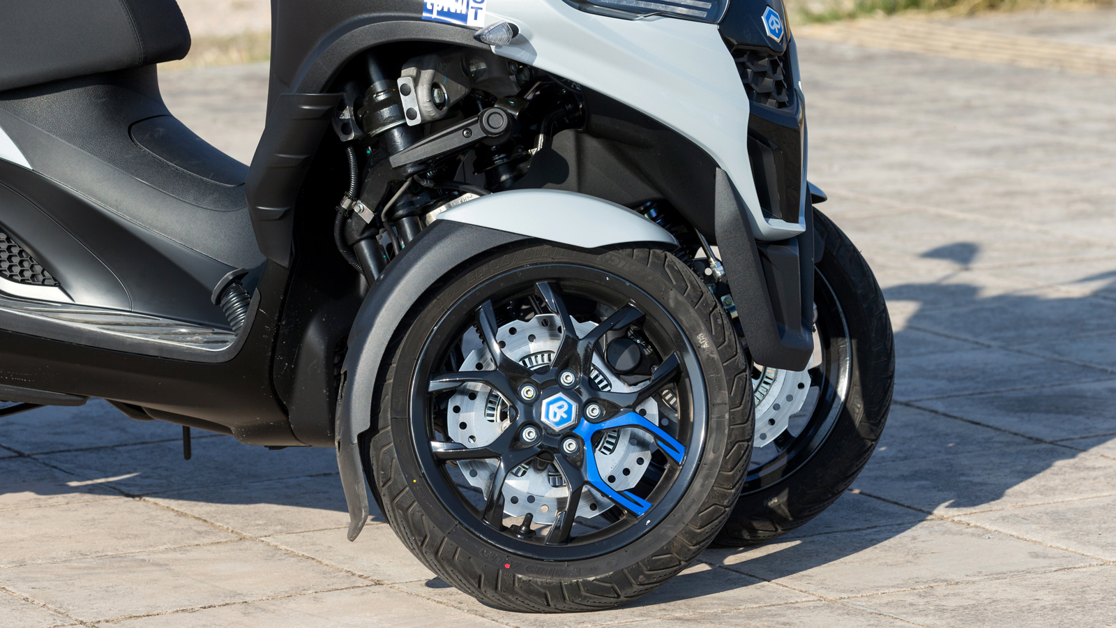 Στο μπροστινό σύστημα ανάρτησης βρίσκουμε το κλασσικό πλέον “αρθρωτό παραλληλεπίπεδο” σύστημα της Piaggio.