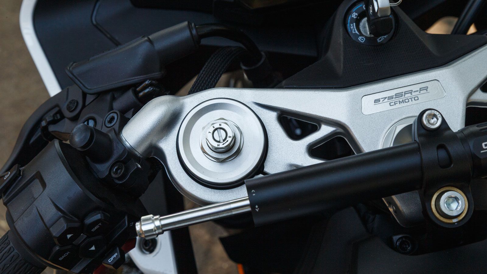 Το πλαίσιο του CFMOTO 675 SR‑R είναι ένα ατσάλινο, σωληνωτό, περιμετρικό πλαίσιο, που συνδυάζεται με ένα σχεδιασμένο από λευκό χαρτί, ελαφ