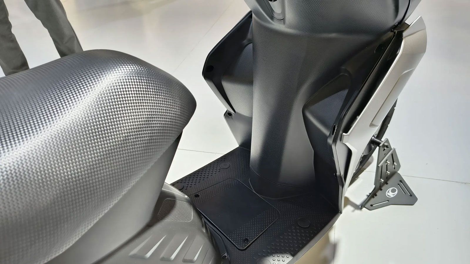 Κάτω από τη σέλα υπάρχει χώρος για κράνος τύπου jet και θύρα USB για φόρτιση συσκευών, ενώ μπροστά υπάρχει δεύτερη ανοιχτή θήκη για μικροαντικείμενα. 
