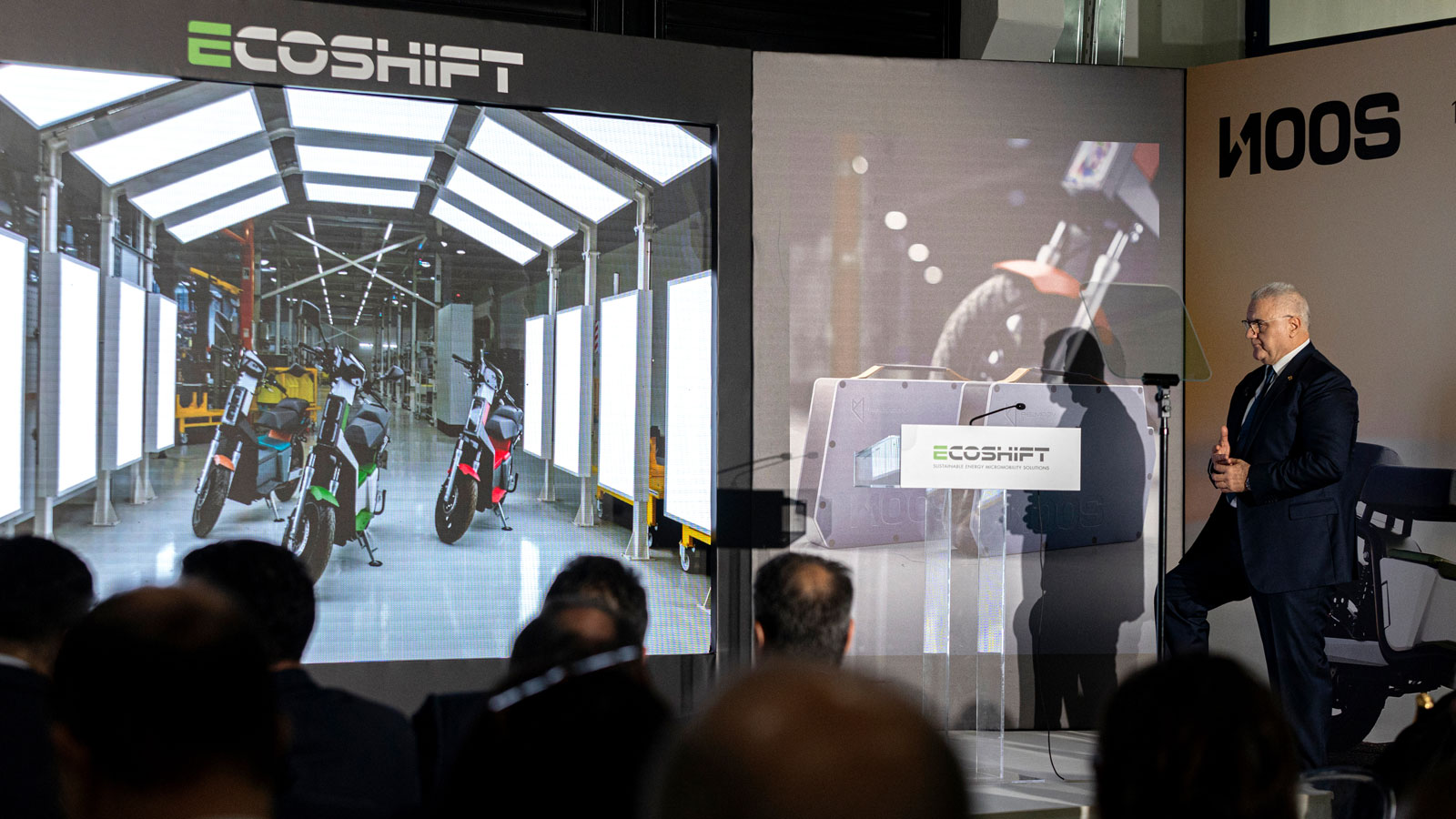 Στο Background φαίνεται το τελικό στάδιο παραγωγής, όπου οι μηχανικοί της Ecoshift κάνουν όλους τους ποιοτικούς ελέγχους στο NOOS πριν βγει από το εργ