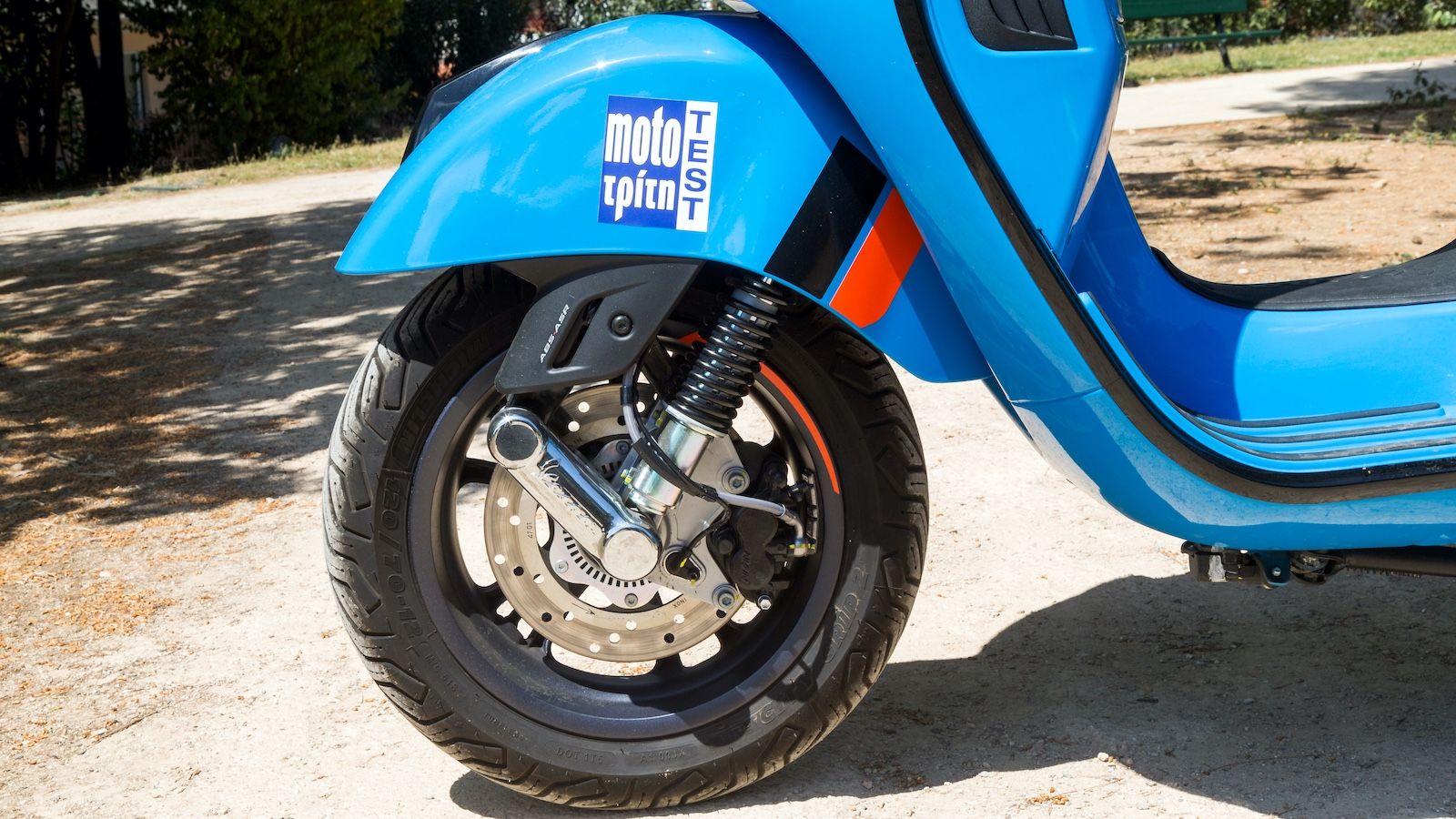 Ένα υδραυλικό αμορτισέρ στο μονόμπρατσο σύστημα εμπρός, σήμα κατατεθέν της Vespa, αποτελούμενο από διπλούς βραχίονες που σχηματίζουν παραλληλόγραμμο κ