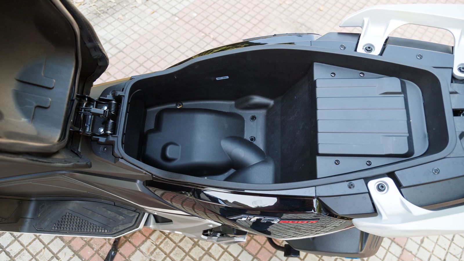 Το εσωτερικό της σέλας κρύβει αποθηκευτικό χώρο ικανό για κράνος τύπου jet και καθημερινά αντικείμενα, με μηχανισμό που με ένα κουμπίτην ανοίγει για ε