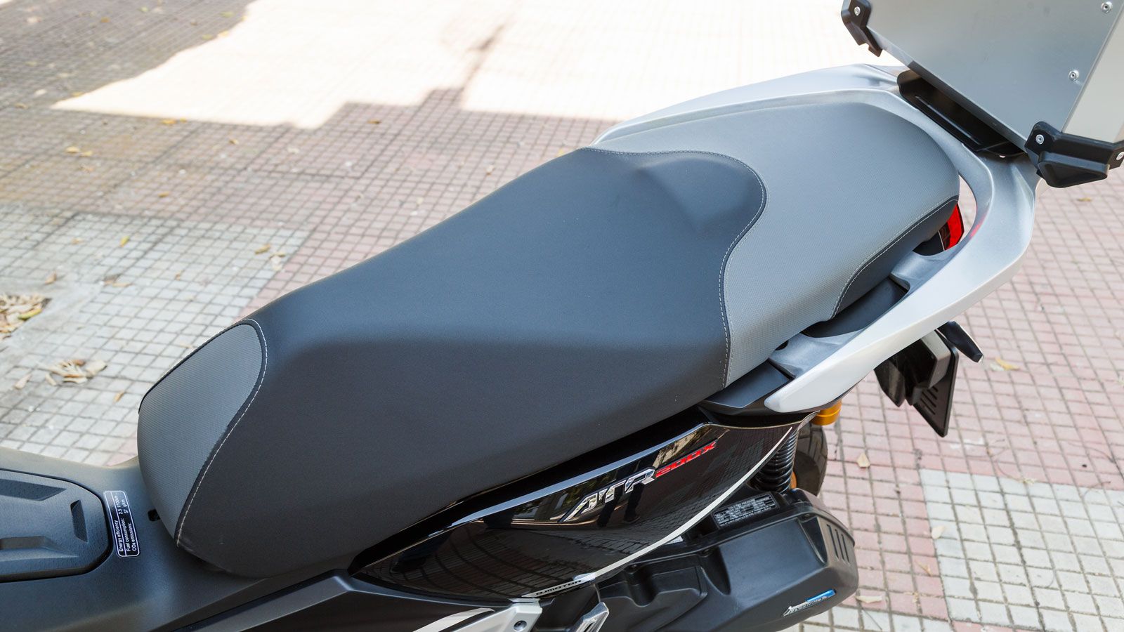 . Η σέλα είναι αρκετά μεγάλη ώστε να φιλοξενεί άνετα δύο άτομα, με ανεξάρτητο τμήμα για τον συνεπιβάτη και πτυσσόμενα αλουμινένια μαρσπιέ που ενισχύου