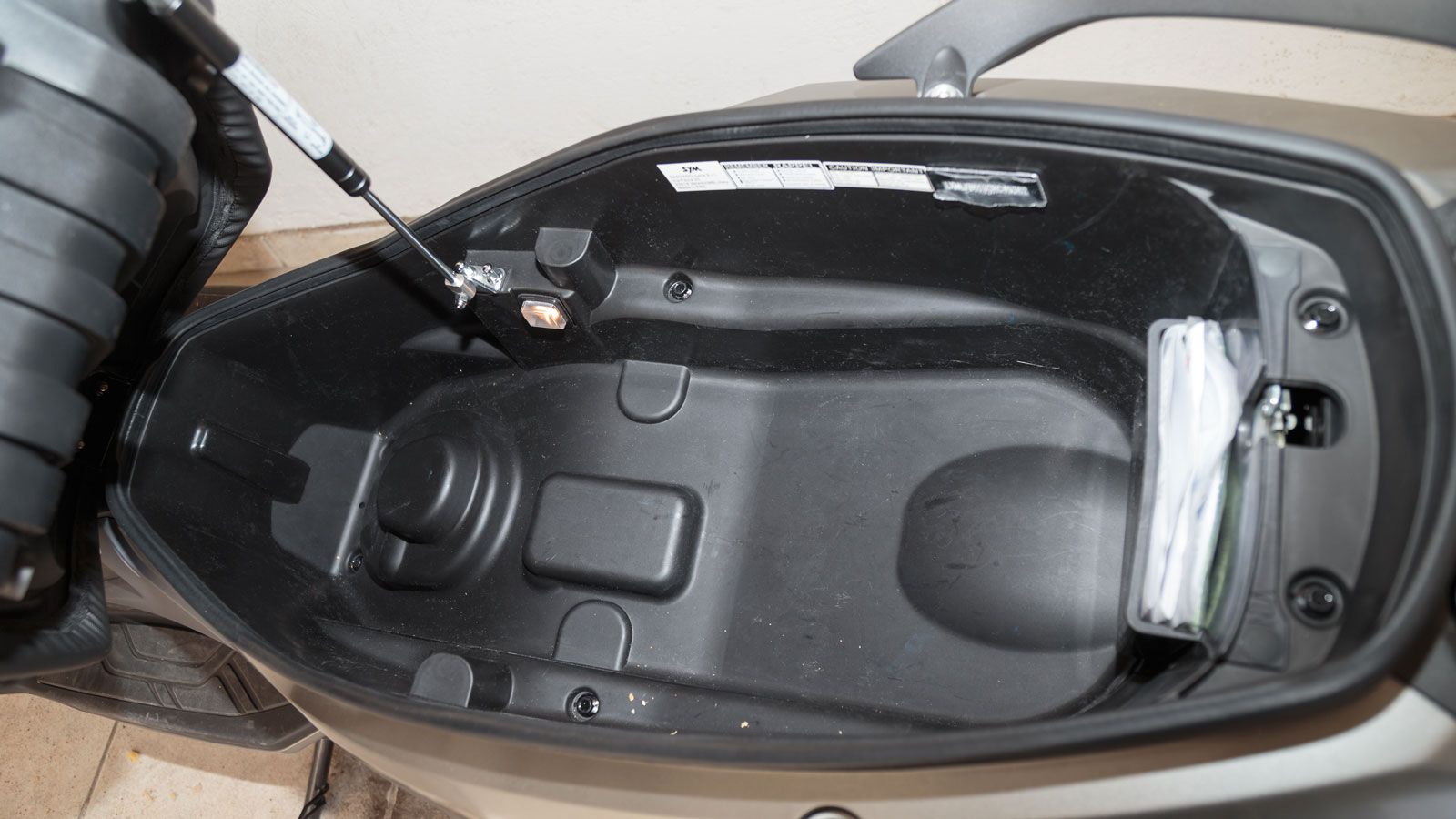  Στο τομέα της πρακτικότητας το Joymax Z3i τα πηγαίνει εξίσου καλά αφού κάτω από τη σέλα έχει αρκετό χώρο για να φιλοξενήσει δύο full face κράνη, αλλά