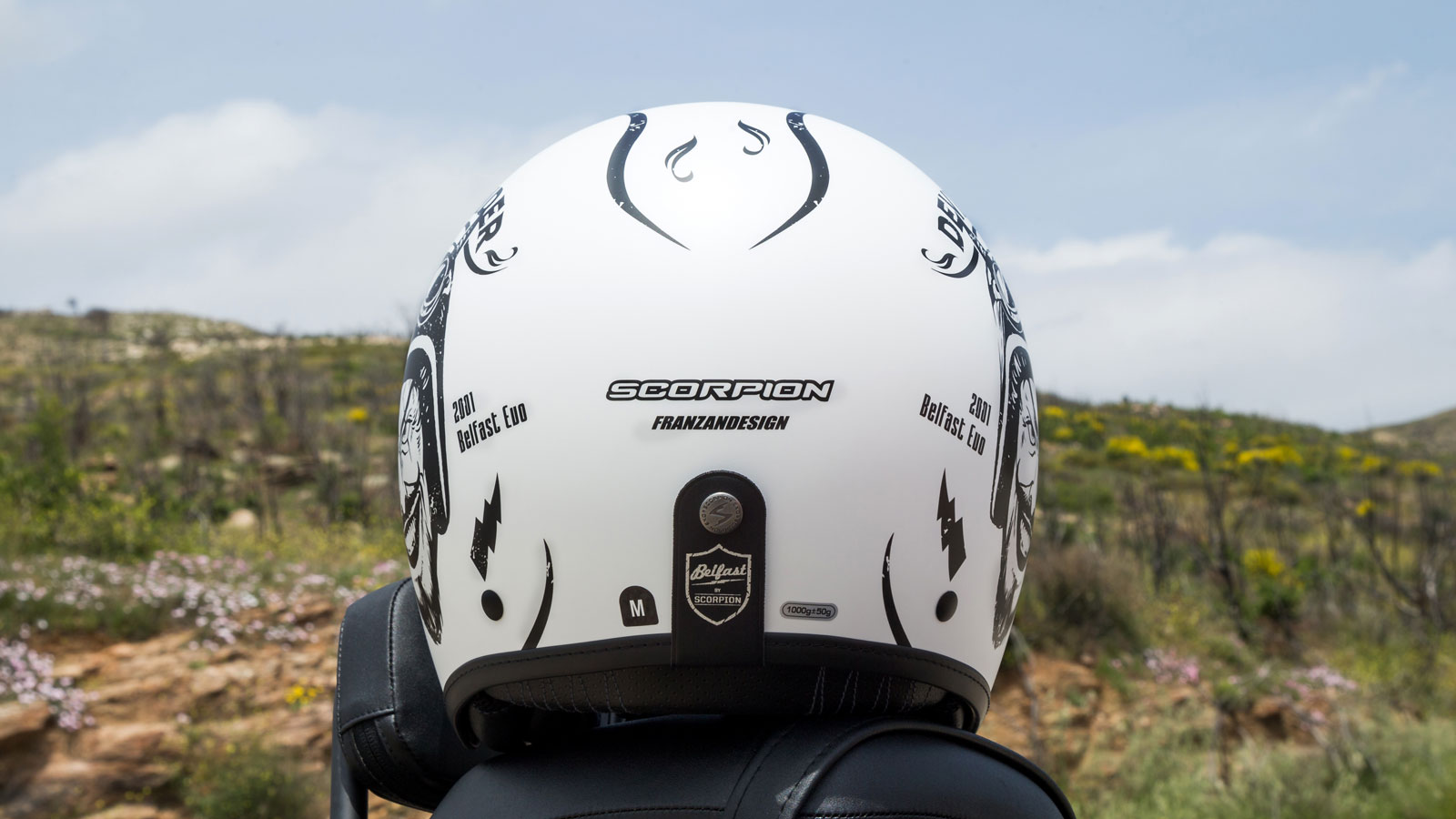 Στο πίσω μέρος του Scorpion-Exo Belfast Evo Romeo θα βρεις ένα μικρό λουράκι με κουμπί από το οποίο μπορείς να περάσεις μάσκα μοτοσυκλέτας για να σταθ