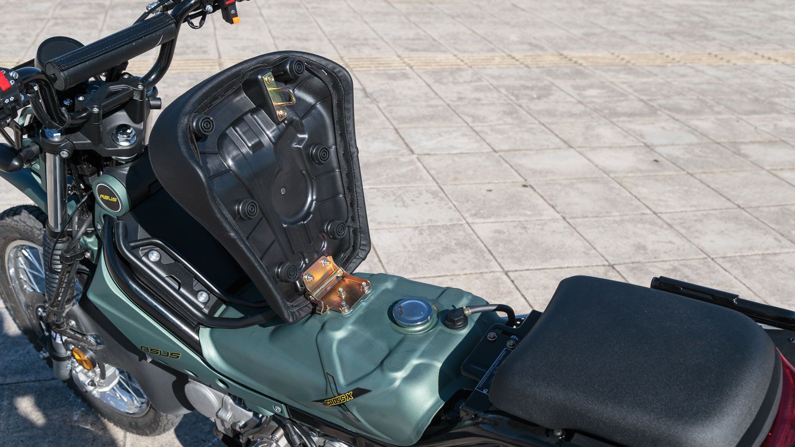 Η σέλα είναι χωρισμένη σε δύο επίπεδα, με το εμπρός τμήμα να ανασηκώνεται για τον ανεφοδιασμό καυσίμου, μια λύση απλή και πρακτική. 