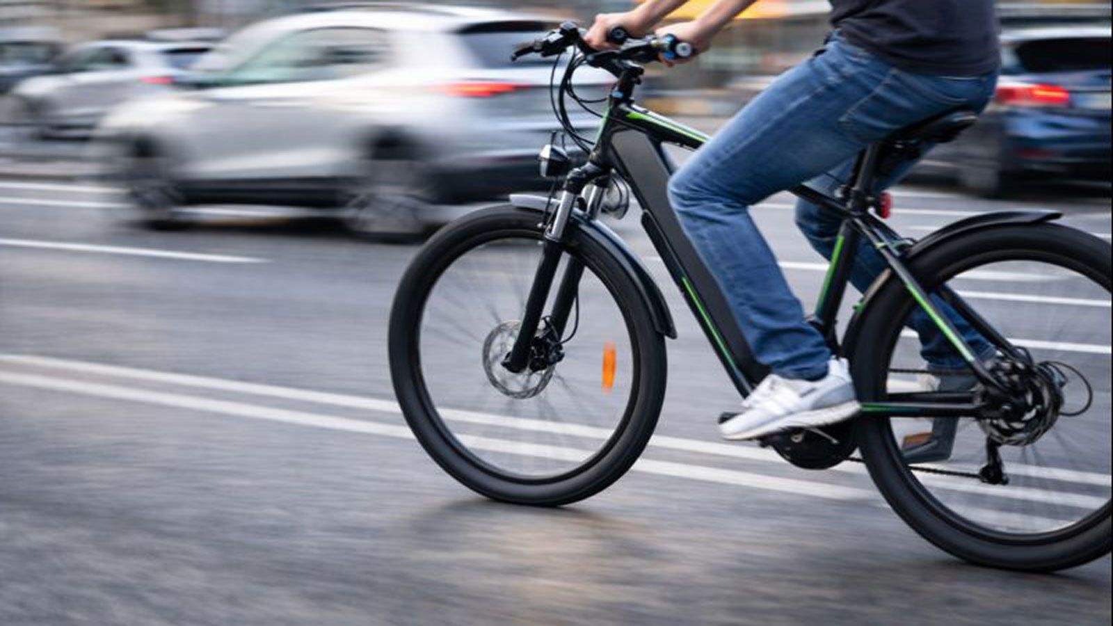 Ηλεκτρικό ποδήλατο με γκάζι κινείται με αυξημένη ταχύτητα σε αστικό δρόμο, αναδεικνύοντας τον κίνδυνο από πειραγμένα ηλεκτρικά δίκυκλα εκτός νομοθεσία