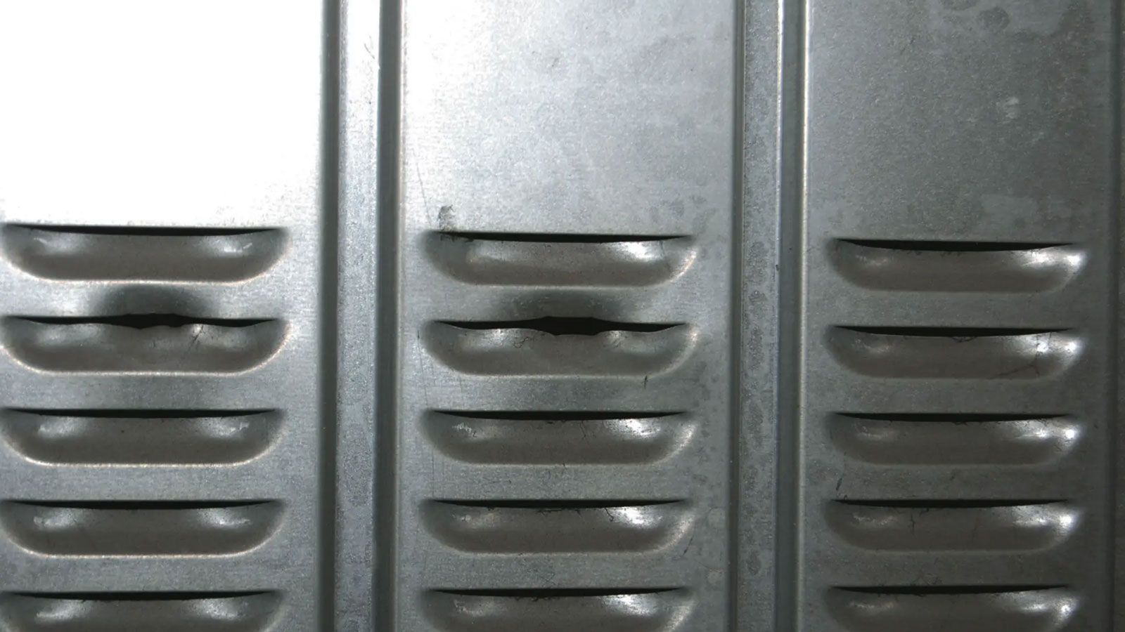 Κοντινό πλάνο σε σχισμές εξαερισμού πόρτας γκαράζ, σημείο που χρησιμοποιούν οι κλέφτες για να ελέγξουν το εσωτερικό.