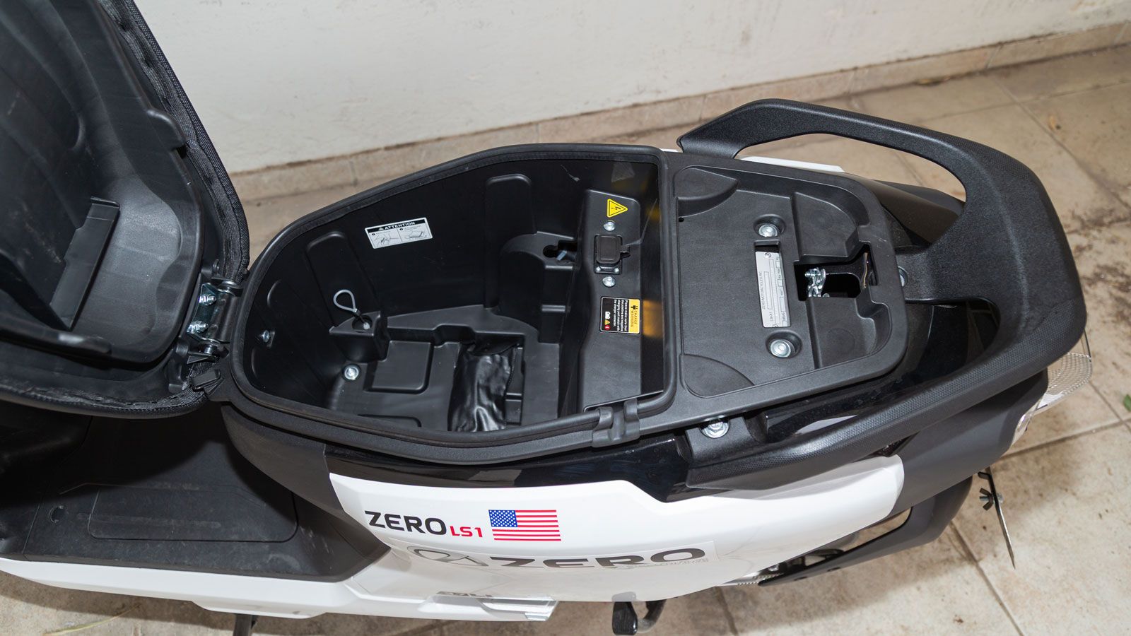 Σε καμία περίπτωση όμως δεν είναι περιττό. Κάτω από τη σέλα, θα βρούμε διαθέσιμο αποθηκευτικό χώρο για ένα κράνος η διάφορα μικροαντικείμενα, ο οποίος