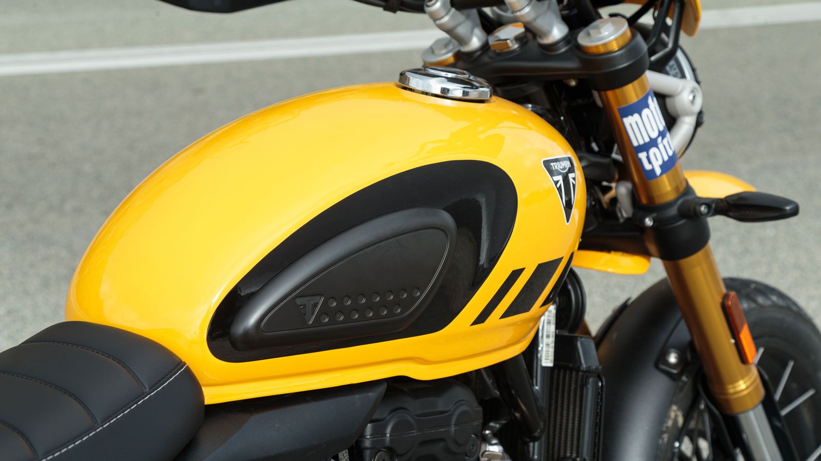 Το σμιλεμένο ρεζερβουάρ με τις βαθιές εσοχές στα γόνατα, τα γεμίσματα και τις αντιθέσεις είναι πλήρως εναρμονισμένο με την Scrambler αισθητική, ενώ το