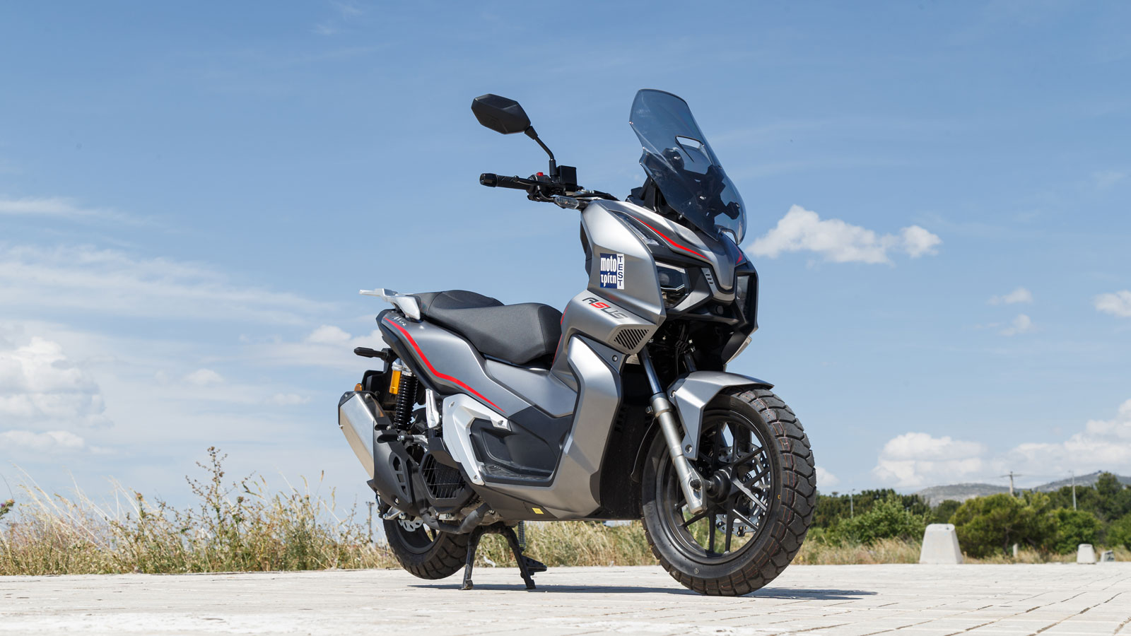 Το ASUS ADV125 ακολουθεί ξεκάθαρα τη σύγχρονη adventure αισθητική, με επιθετικές γραμμές και αιχμηρή σχεδίαση που του χαρίζουν επιβλητική παρουσία στον δρόμο, παρά το μαζεμένο μέγεθος του.
