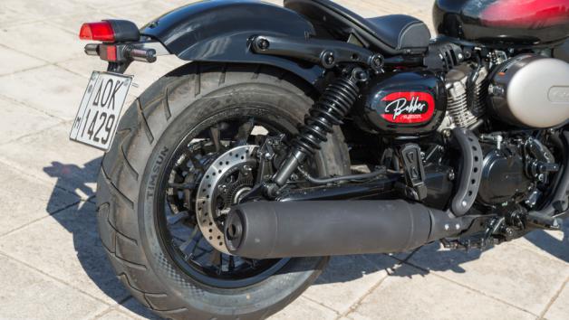 Πίσω, η Hyosung τοποθετεί διπλή ανάρτηση με ελατήρια και ρυθμιζόμενη προφόρτιση, διατηρώντας το κλασικό bobber look. Ο συνδυασμός μπροστινής USD και διπλών πίσω αμορτισέρ υποστηρίζει το αυξημένο βάρος του μοντέλου και ολοκληρώνει ένα προσεγμένο σύνολο.
