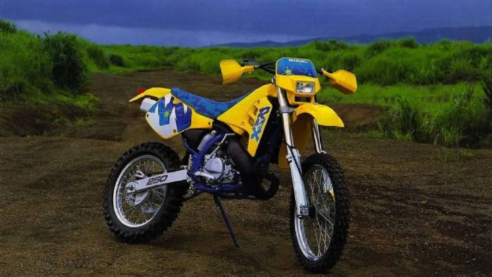 Στα 90s, η Suzuki RMX250S έμοιαζε λες και βγήκε κατευθείαν από το parc fermé ενός αγώνα enduro. Προερχόταν από την αγωνιστική RMX250, που είχε ρίζες στη motocross RM, και ήταν κάτι πολύ περισσότε